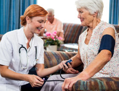 nurse checking blood pressure of a senior woman