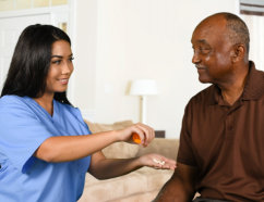 caregiver handing a medicine to a senior