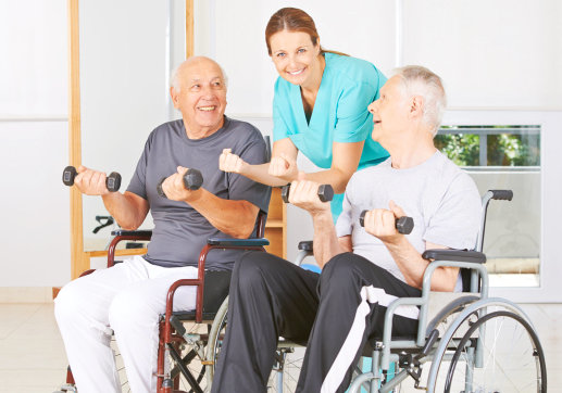 caregiver assisting two seniors on their excercise