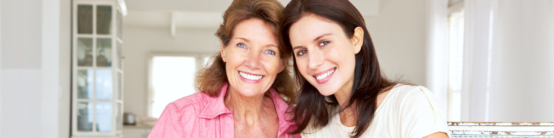 senior and a caregiver smiling together