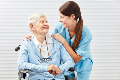 senior and caregiver smiling at each other